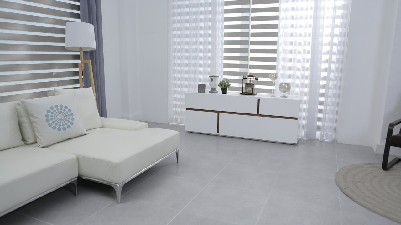 Bright and spacious living room featuring modern minimalist decor, a white sofa, and sleek furniture.